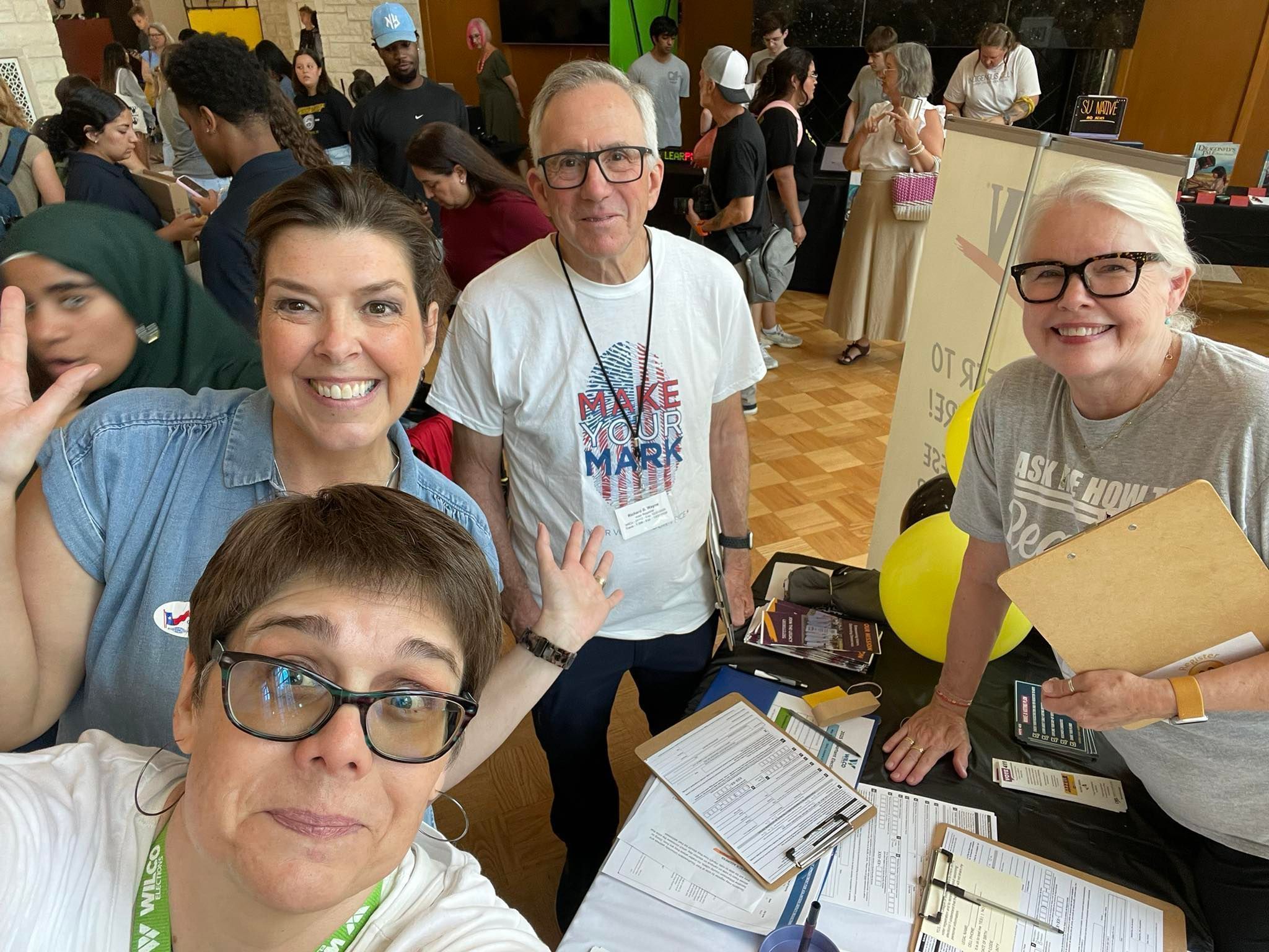 Felicia makes a goofy face as Shelley, Richard, and Carol smile in the background while they volunteer at a voter registration event at Southwestern