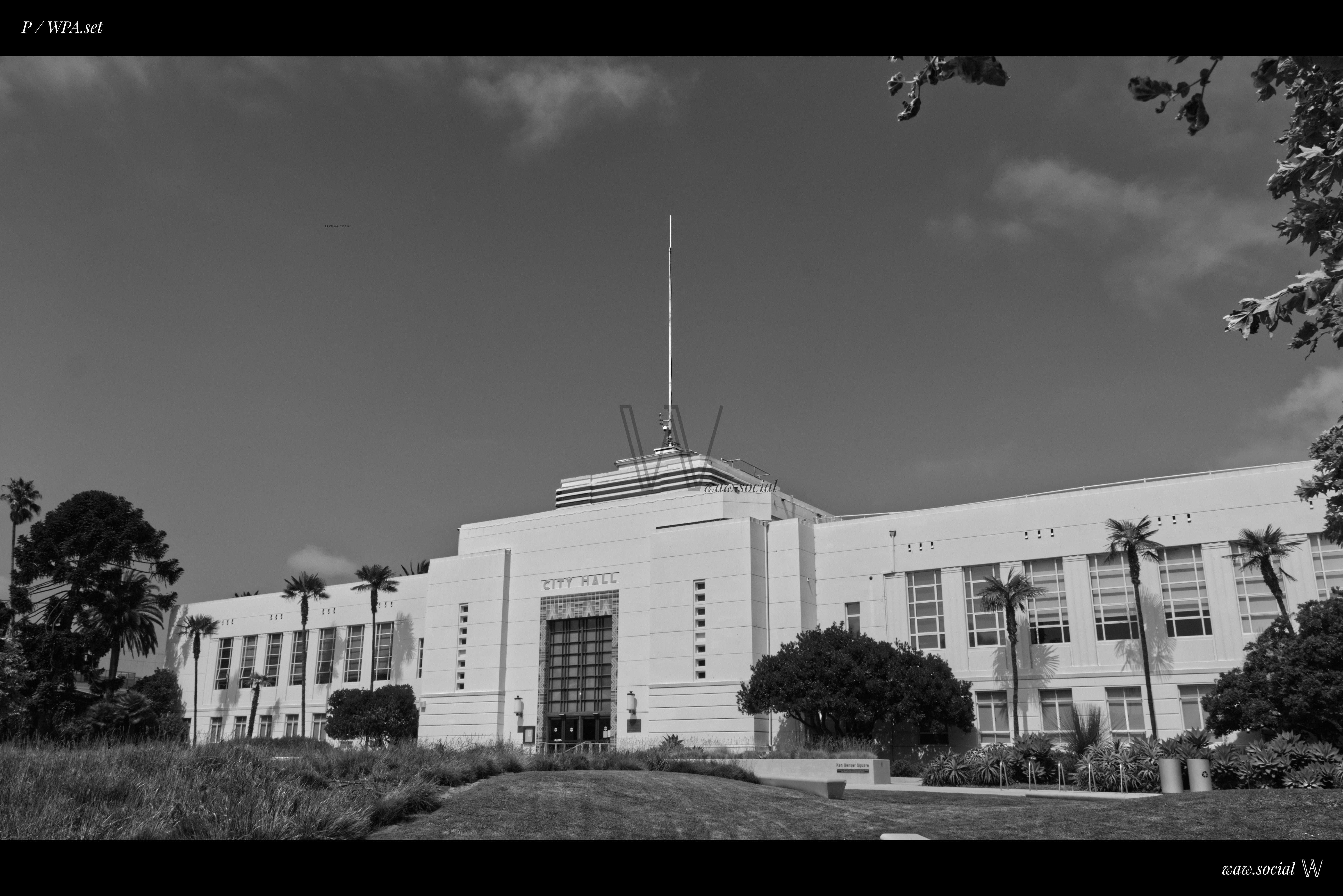 A black and white photo of Santa Monica City Hall in California framed by natured.