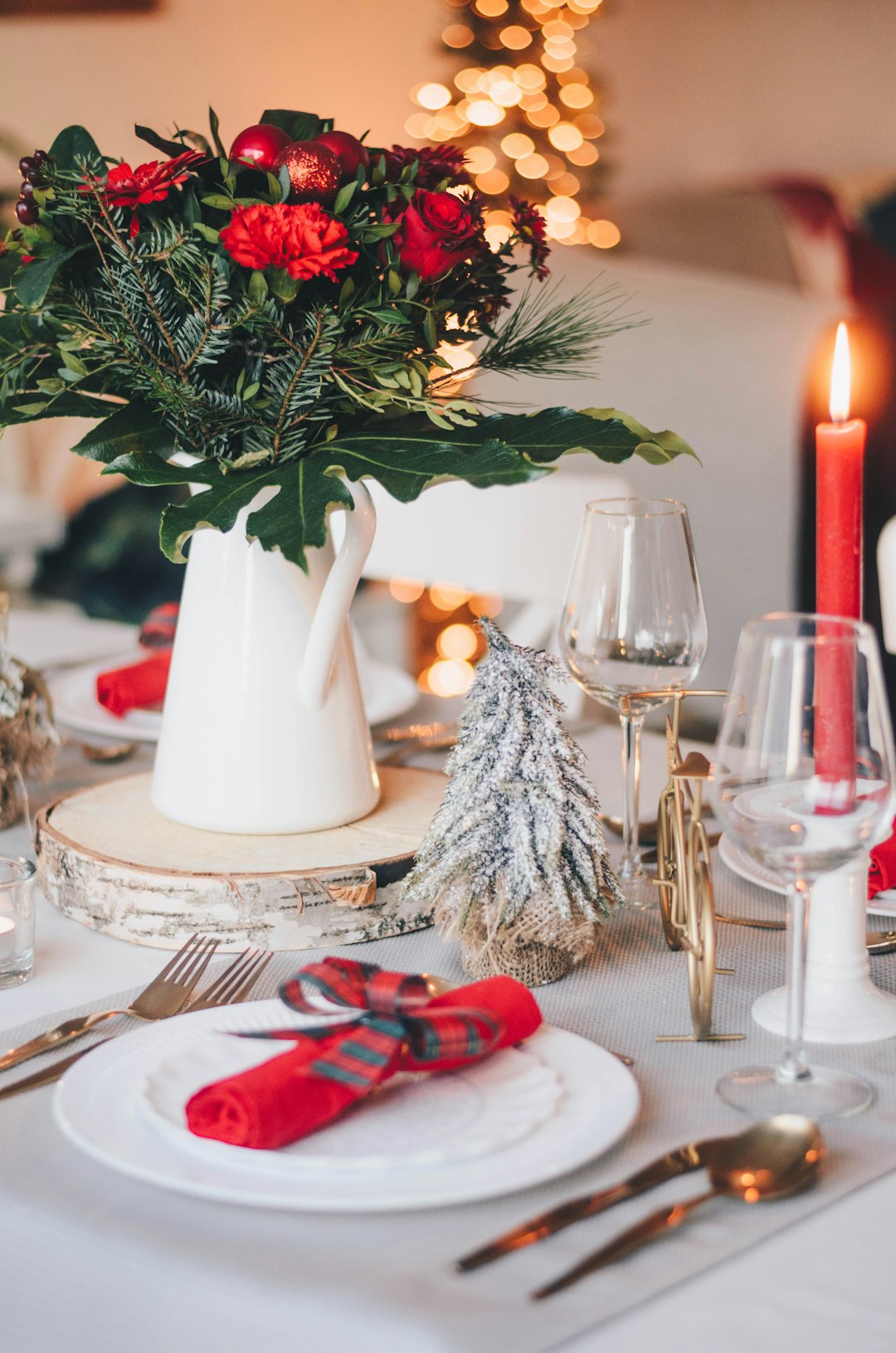Christmas dining table set with plates, greenery and festive decorations, ready for visitors